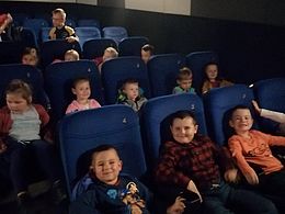 dzieci siedzące w sali kinowej