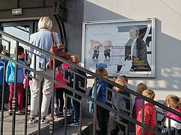 dzieci wchodzące po schodach do budynku kina