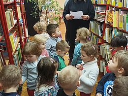 dzieci przeglądają półki biblioteczne