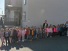 dzieci z nauczycielkami pozujące przed budynkiem