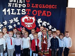 Dzieci z kokardami narodowymi na tle dekoracji