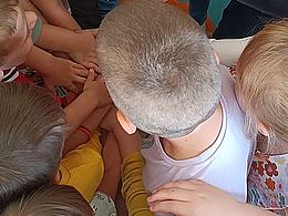 Ręce dzieci ułożone w kole jedna na drugiej 