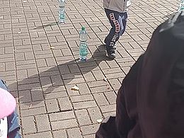 chłopiec biegnie z piłeczką na talerzyku między butelkami z wodą