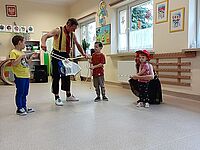 trójka dzieci ierze udział w sztuczce z liną i chusteczką