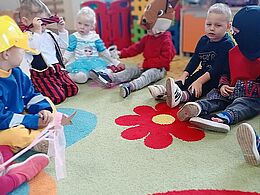 Dzieci w przebraniach przekazują sobie kubek 