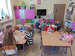 dzieci z grupy muchomorków jedzące pączki