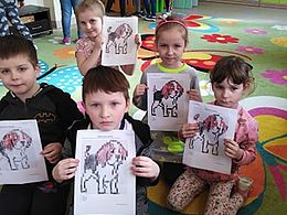 Dzieci z grupy motylków prezentujące pracę plastyczną - psy wyklejone papierem toaletowym