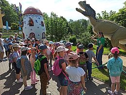 Dzieci oglądają postać dinozaura