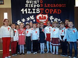 Dzieci z kokardami narodowymi na tle dekoracji