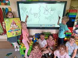 Dzieci wskazują obrazki na tablicy multimedialnej