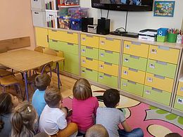Dzieci oglądające film edukacyjny na telewizorze