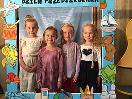 4 dziewczynki pozują w niebieskiej fotobudce
