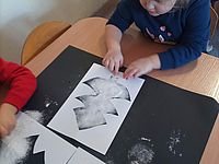 Dziecko z obsypanym mąka szablonem choinki 