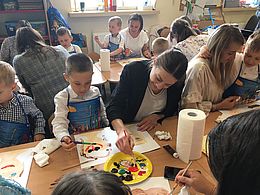 Dzieci i rodzice malują farbami swoje portrety
