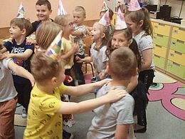 Dzieci podczas zabawy "Pociąg" - chodzą jedno za drugim trzymając się za ramiona