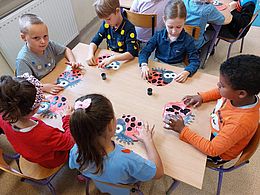 Dzieci kolorują obrazki biedronek 