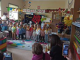 dzieci stoją w rzędzie na tle dekoracji