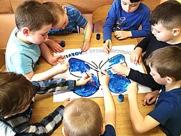dzieci malują farbami dużego motyla