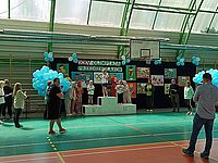 Dzieci stoją na podium na hali sportowej 