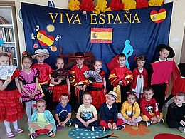 Dzieci w strojach hiszpańskich pozują na tle dekoracji