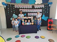 Grupa pozuje na tle napisu Światowy Dzień Świadomości Autyzmu 