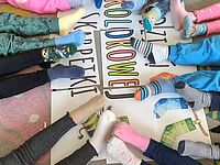 Napis dzień kolorowej skarpetki wokół nogi dzieci 