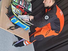 Ratownik medyczny pokazuje sprzęt potrzebny w pracy 