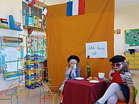 Dziewczynki piją z filiżanek na tle dekoracji związanej z Francją 