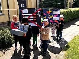 dzieci z plakatami podczas przemarszu ulicami miasta