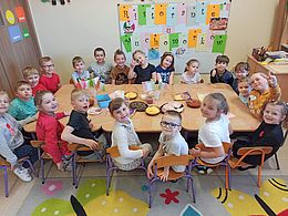 Dzieci pozują przy stolikach na tle dekoracji związanej z Włochami 