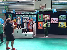 Dzieci z medalami stoją na podium 