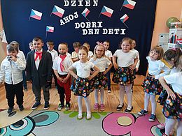 Dzieci pozują na tle dekoracji związanej z Czechami 