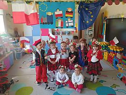 Dzieci pozują na tle dekoracji związanej z Polską 